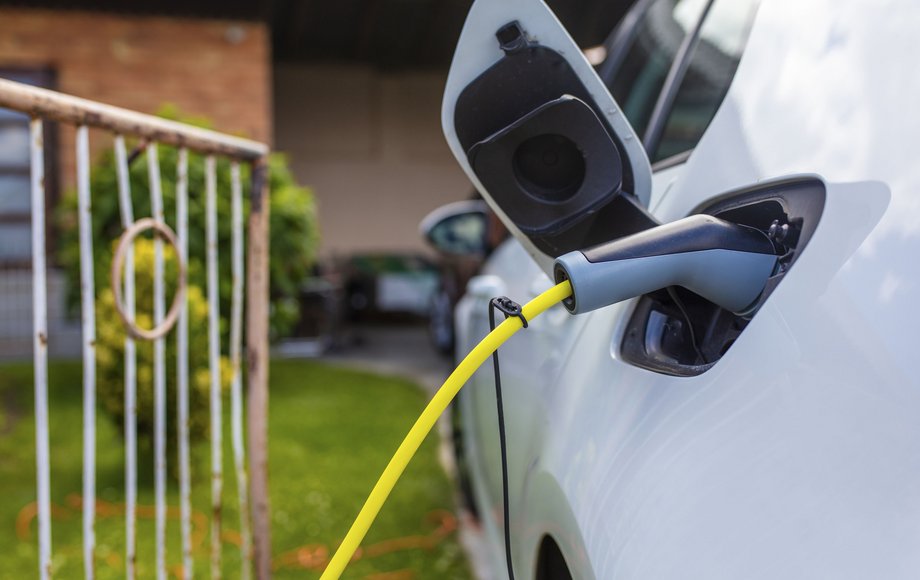 Seite eines Elektroautos mit eingestecktem Ladekabel