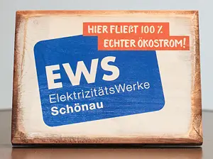 Holzaufsteller mit Text "Hier fließt 100% Ökostrom" und EWS-Logo