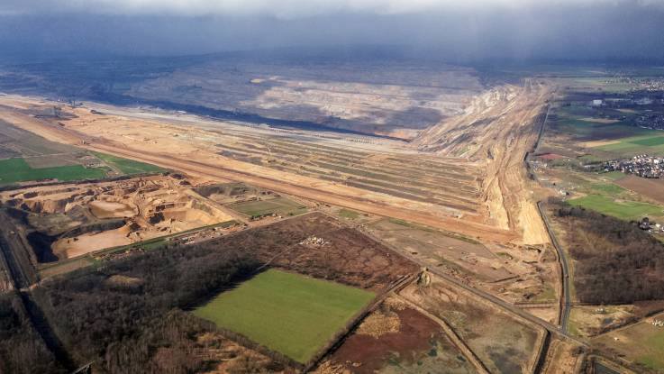 Luftaufnahme des Tagebaugeländes am Hambacher Forst, am rechten Bildrand ein Dorf