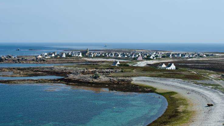 Die Küstenlinie zieht sich im Bogen, im Hintergrund liegt der Ort Île de Sein.