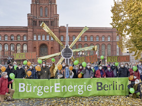 Menschengruppe mit Banner und Luftballons vor Berliner Rathaus