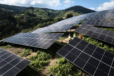 Der Solarpark Fröhnd aus Vogelperspektive, zwischen den Modulen sind drei Menschen in Warnwesten zu erkennen