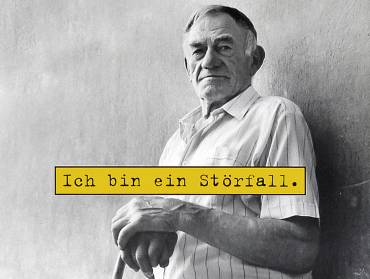 Ein alter Mann stützt sich auf einen Stock, darüber der Kampagnenslogan «Ich bin ein Störfall» auf gelber Fläche.