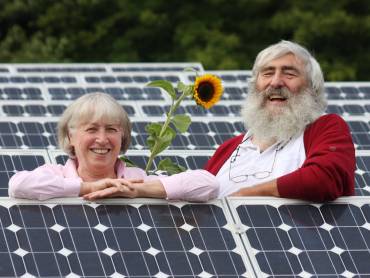 Ursula und Dr. Michael Sladek mit Sonnenblume, inmitten von Photovoltaik-Modulen