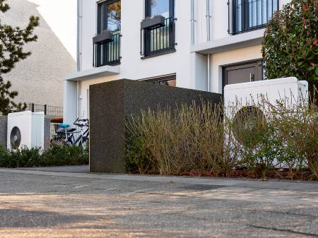 Zwei Häuser einer Reihenhaussiedlung, welche beide eine Wärmepumpe im Vorgarten stehen haben