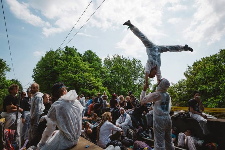 Ein Aktivist macht einen Handstand auf den Händen eines stehenden Aktivisten, weitere sehen zu.