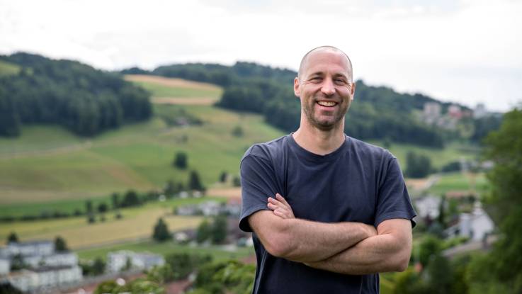 Martin Kohli lacht in die Kamera, mit verschränkten Armen und voller Tatendrang.