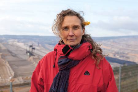 Frau Grothus in roter Jacke  vor dem Tagebaugelände