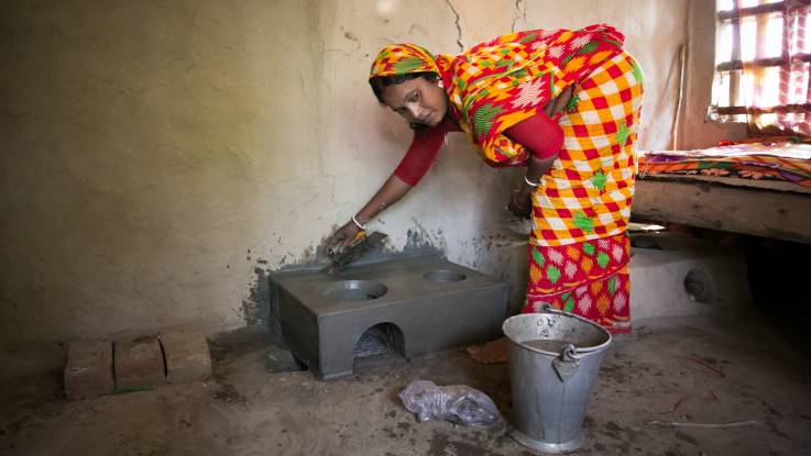 Savita Sardar verputzt den neuen Herd mit einer Kelle