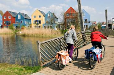 Blick über eine Brücke zur Siedlung mit bunten Häusern