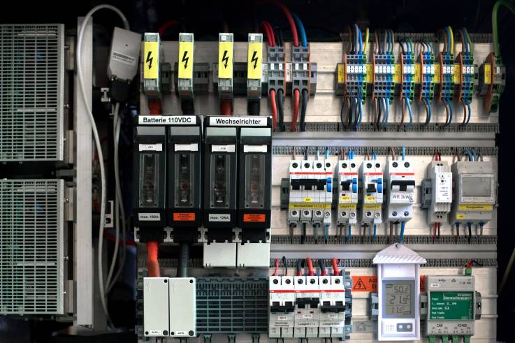 Das Innenleben einer Salzbatterie; die miteinander verkabelten Bauteile sind unter anderem mit «Batterie 110VDC»  und «Wechselrichter» beschriftet, ein LCD-Display zeigt die Betriebstemperatur an