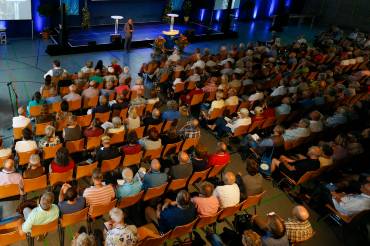 Halle mit vielen Zuhörern und einem Redner