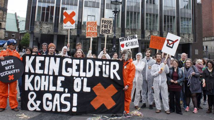 Eine Gruppe Demonstranten mit einem großen Transparent, auf dem «Kein Geld für Kohle, Öl& Gas!» steht.