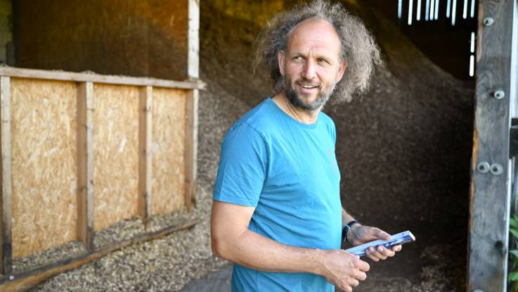 Ein Mann mit leicht ergrauter Mähne im blauen T-Shirt blickt in die Kamera.