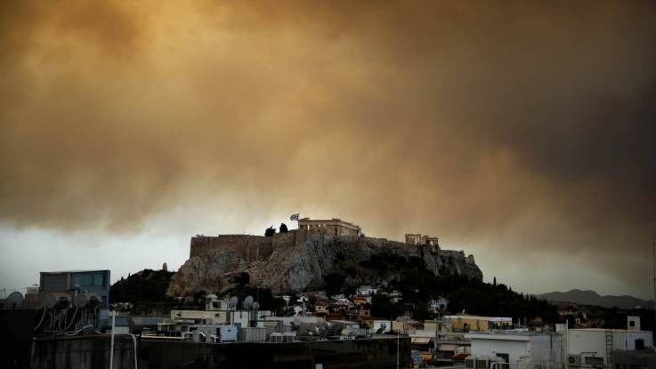 Rauschwaden mit orangenem Feuerschein über der Akropolis