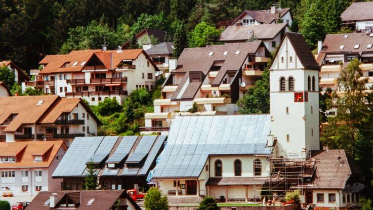 Ansicht des Ortes Schönau, im Zentrum die Kirche mit dem komplett mit PV-Modulen bestückten Dach.