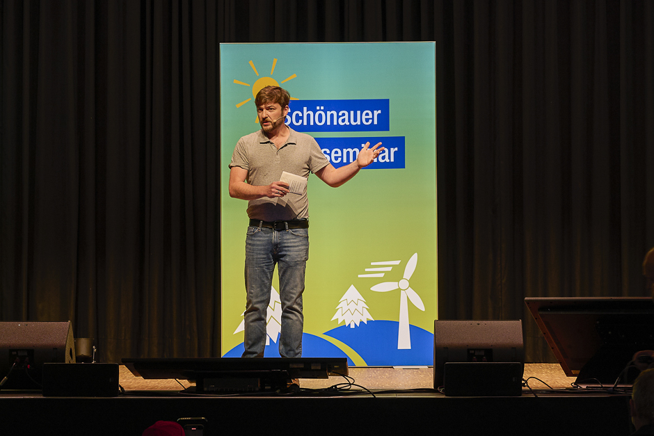 Sebastian Sladek spricht auf der Bühne mit ausladender Geste.