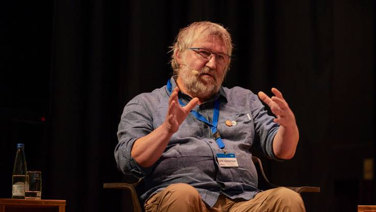 Dirk Vansintjan in Nahaufnahme, spricht auf der Bühne.