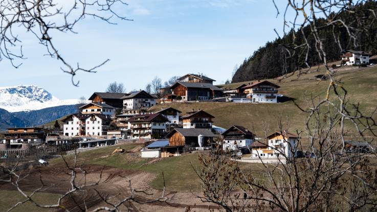 Blick auf den Ort St. Peter: Eine Gruppe von zwei- bis dreigeschossigen Häusern, dazwischen stehen große Scheunen.