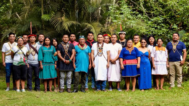 Gut zwanzig Personen posieren für ein Gruppenbild – ihre Kleidung ist ein Mix aus traditionellen und modernen Elementen. 