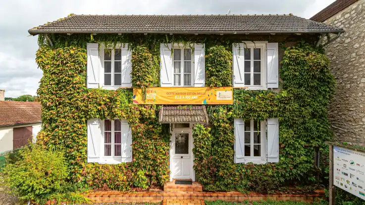 Dasselbe Haus in heutiger Zeit, ist als Strohbau nicht zu erkennen. Es ist vollflächig mit Wein bewachsen.